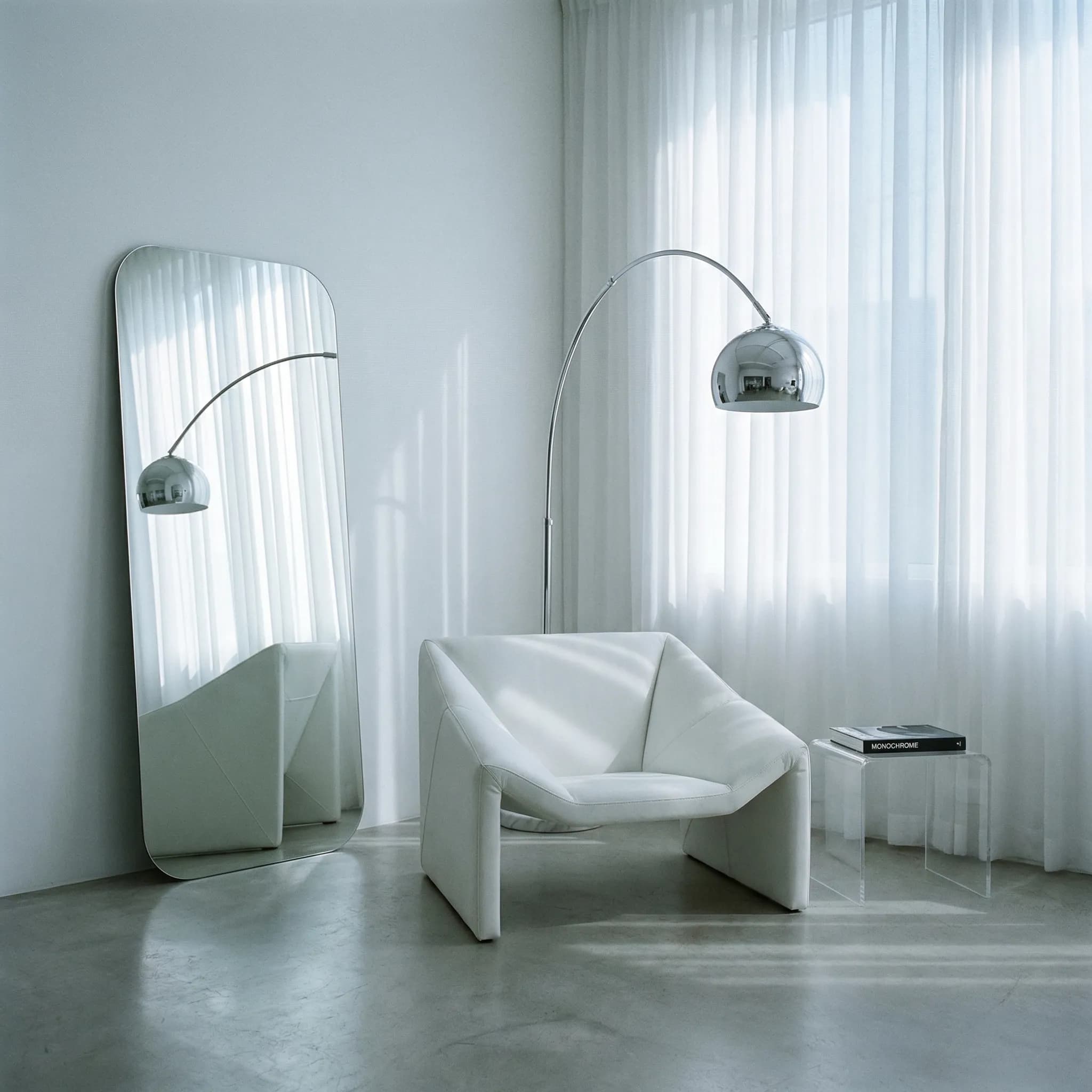 Ultra-minimal white living room with chrome arc lamp