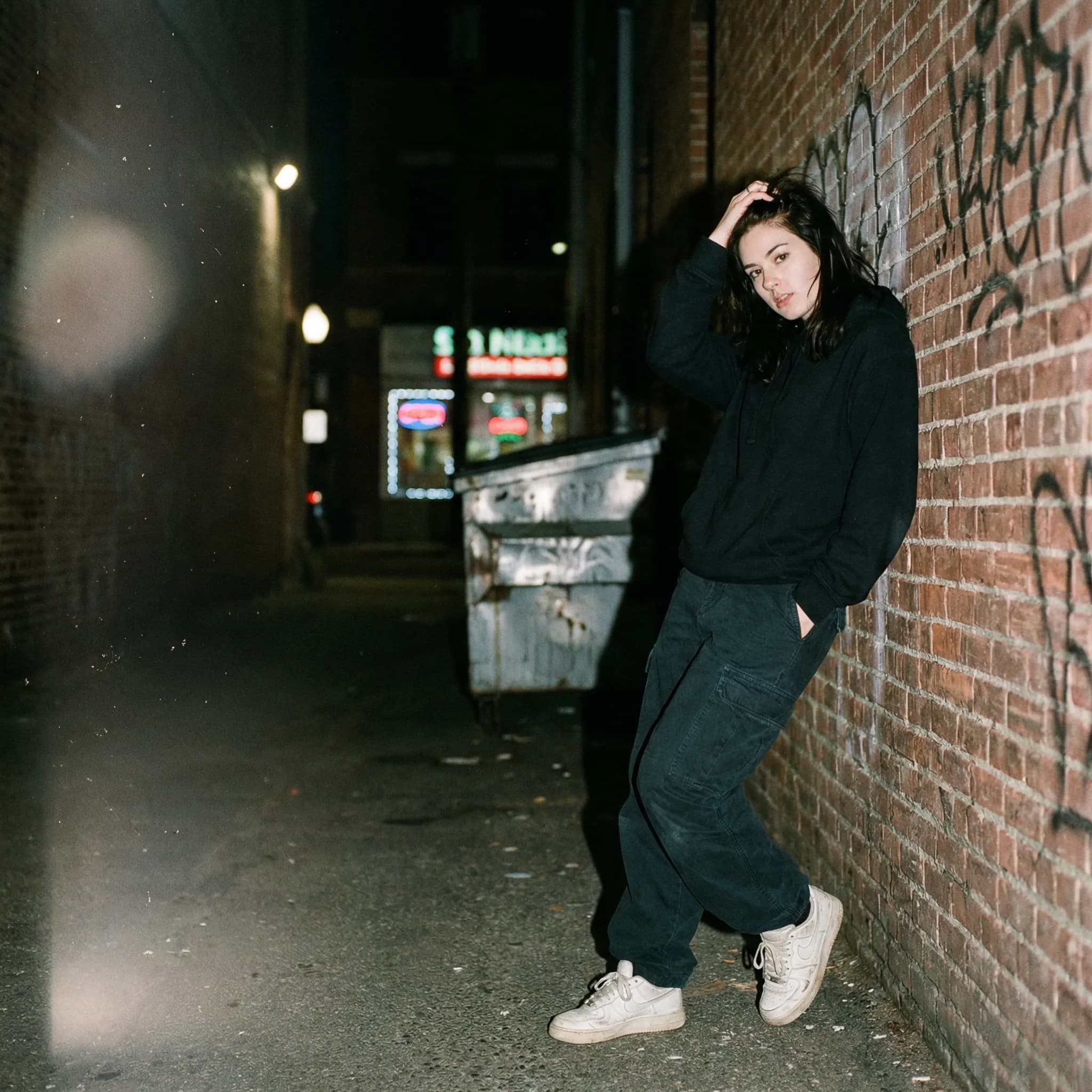 Candid flash photo of woman in brick alley at night